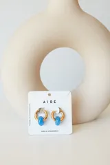 Aros dorados con dije circular de piedra natural negra.