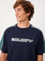 Remera negra de manga corta con diseño deportivo, parte superior de las mangas en color gris con ribete blanco y estampa frontal con la marca Rusty.