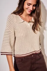 Sweater de tejido abierto de algodón, color beige, con cuello polo, mangas cortas y detalles en color marrón oscuro en los bordes y puños.