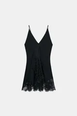 Top satinado de viscosa color negro, con escote en V, tirantes finos y detalles de bordados a tono en la parte inferior.