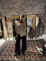 Chaleco tejido color beige con terminación en flecos.