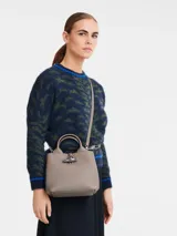 Cartera de mano tamaño pequeño Longchamp de la línea Le Roseau, color verde, de diseño estructurado con doble asa y cierre de botón a presión con pasador metálico tubular.