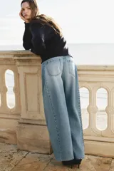 Jean de cinco bolsillos en denim de algodón rígido, de diseño curvo con volumen y corte holgado de cadera a muslo, algo más ceñidas en el bajo. Cintura clásica con cierre y botón.
