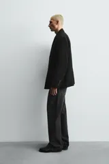 Blazer de corte relajado confeccionada en tejido fluido con mezcla de viscosa. Presenta cuello con solapas de muesca, manga larga con puños abotonados, bolsillos de solapa en la cadera y cierre frontal con botones.