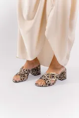 Sandalia color beige con tiras cruzadas y hebilla metálica cuadrada. Taco cuadrado de 6 cm.