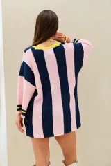 Remerón tejido de punto oversize con diseño de rayas verticales en color azul marino y rosado, cuello en V con borde amarillo y mangas largas.