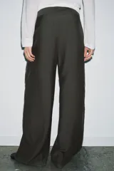 Pantalón de tiro medio con diseño wide leg, confeccionado en mezcla de lyocell. Presenta detalle de pinzas en el delantero, cierre frontal con cremallera, botón y ganchos metálicos.