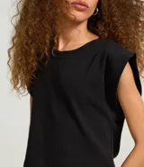 Blusa sin mangas de algodón color negro, con cuello redondo y hombreras marcadas.