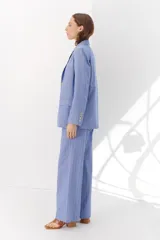 Blazer de lino color crudo con rayas verticales finas en color dorado, de corte recto, con solapas y cierre con un botón.