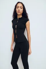 Top de tejido elástico color negro, con cuello mao, manga muy corta y cierre frontal con alamares decorativos.