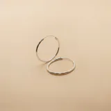 Par de aros tipo argolla de diseño minimalista, fabricados en plata 925 con acabado pulido.