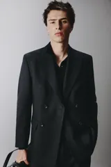 Blazer cruzado regular fit negro, con solapa de pico, bolsillos con solapa en la cadera, bolsillo de vivo en el pecho y cierre frontal con doble botonadura.