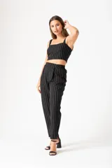 Top negro con rayas verticales blancas, breteles finos y corte cropped.