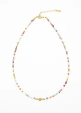 Gargantilla corta de acero quirúrgico hipoalergénico con mostacillas brillantes de colores y dije central dorado en forma de rombo.