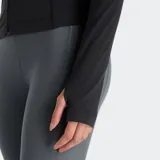 Campera deportiva New Balance de ajuste entallado, color negro, con cierre frontal completo, cuello alto y mangas largas. Presenta costuras reforzadas y el logo reflectante de la marca en el pecho.