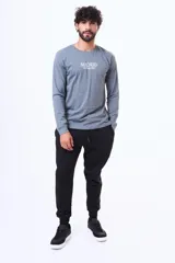 Remera de manga larga color gris, con cuello redondo y estampa frontal con el texto 'MADRID moving cities' en color blanco.