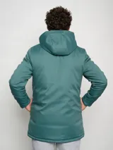 Parka larga gris con capucha, cierre frontal con cremallera y botones a presión, múltiples bolsillos y logo de Umbro en el pecho.