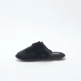 Pantuflas tipo mule de color negro, confeccionadas en material aterciopelado con detalle de borde en pelo sintético. Poseen suela plana y diseño abierto en el talón.