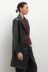 Blazer negro de eco cuero con solapas, cierre de botón frontal y pespuntes blancos en los bordes.