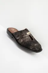 Zuecos de cuero color bordó con punta cuadrada, detalle de abertura en el empeine y aplique metálico dorado.