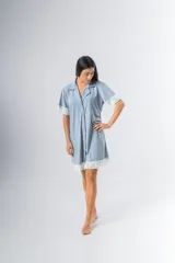 Camisa celeste con estampado a rayas verticales, de corte recto, con cuello camisero, cierre frontal con botones, mangas cortas con detalle de puntilla y ruedo con puntilla.