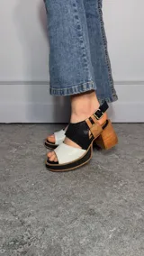 Sandalias con taco ancho y plataforma, confeccionadas en combinación de napa blanca, cuero texturizado croco negro y napa camel. Cuentan con tira trasera con hebilla metálica regulable.