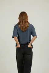 Remera de algodón de manga corta y cuello redondo, con diseño holgado y estampado gráfico frontal con motivos florales y tipografía vintage.