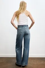 Jeans de mujer tiro alto, color celeste claro lavado, con cinco bolsillos y pierna extra ancha y larga.