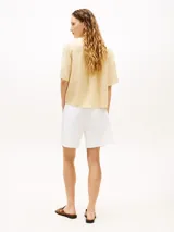 Camisa de manga corta Tommy Hilfiger de corte amplio y color beige, confeccionada en puro lino. Presenta cuello inglés, cierre frontal de botones, un bolsillo de parche en el pecho con el logo bordado y hombros ligeramente caídos.