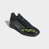 Championes de fútbol Adidas F50 League para césped artificial, color negro con detalles en amarillo y plateado. Presentan exterior Fiberskin con estampado Sprintgrid y lengüeta Tunnel adaptable.