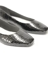 Chatitas negras con textura efecto reptil, acabado charolado, punta fina y taco bajo con detalle metalizado.