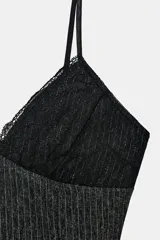 Top lencero con escote en pico y tirantes finos. Presenta un diseño combinado con encaje negro en la parte superior y tejido de raya diplomática en el cuerpo. Posee bajo redondeado.