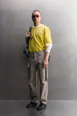 Camiseta de corte relaxed fit color amarillo, confeccionada en tejido compacto de algodón, con cuello redondo, manga corta y estampado frontal a contraste con texto y motivo floral pequeño.