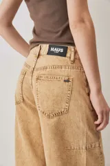 Jeans de corte barrel en color tostado, con diseño de perneras curvadas y costuras pespunteadas.