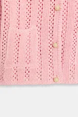 Chaqueta de punto pointelle en color rosado, con cuello redondo, manga larga y bolsillos delanteros de parche. Cuenta con cierre frontal de botones claros.
