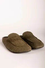 Zueco tipo mocasín destalonado en color verde oliva, con textura grabada efecto cocodrilo y acabado en gamuza.