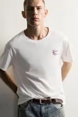 Camiseta relaxed fit de color blanco con efecto lavado, cuello redondo y manga corta. Presenta un pequeño estampado a contraste en el pecho izquierdo.