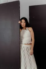 Conjunto de top y pollera color crema con ribetes negros. El top es musculosa con cuello redondo y la pollera es larga con estampado abstracto.