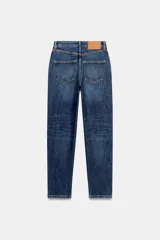 Pantalón jeans Z1975 de tiro alto y diseño mom fit, color azul claro con lavado desgastado, de corte tobillero y cinco bolsillos. Cierre frontal con cremallera y botón metálico.