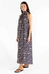 Vestido largo negro con cuello halter y estampado exclusivo de pequeños círculos y peces. Diseño sin mangas y corte fluido.