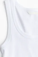 Musculosa blanca de punto acanalado, con escote redondo y tirantes anchos.