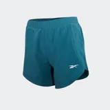 Short de running Reebok color azul verdoso (teal) con cintura elástica y logo reflectante de Reebok en la pierna. Presenta aberturas laterales en el ruedo para mayor movilidad.