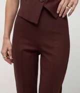 Pantalón de corte flare confeccionado en tejido Punto Roma, con diseño de tiro alto, recortes verticales a lo largo de las piernas y cintura elástica sin cierre.