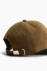 Gorra de sarga de algodón con efecto lavado en color verde militar, con bordado frontal con la frase "Atelier Créatif" en hilo claro.