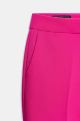 Pantalón de tiro alto color fucsia, de corte recto, con bolsillos delanteros, falsos bolsillos de vivo en la espalda y raya marcada en las perneras. Cierre frontal con cremallera, botón interior y gancho metálico.