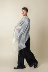Chal de organza con tejido de lurex brillante, diseño ligero y traslúcido con terminación de flecos en los extremos.