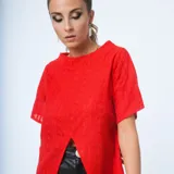 Remera roja de manga corta con textura bordada, escote redondo y tajo frontal en el dobladillo.