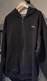 Campera con capucha y cierre frontal completo, confeccionada en algodón de alto gramaje. Presenta un diseño minimalista con bordado en el pecho y corte oversize.