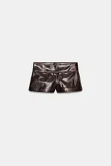 Shorts de tiro bajo confeccionados en material con acabado efecto cuero brillante. Presentan cintura ancha con detalle de botones forrados en el frente y cierre frontal con cremallera.