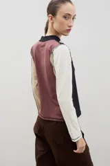 Remera de cuello alto y manga larga en color crudo, con costuras a la vista en contraste de color marrón.